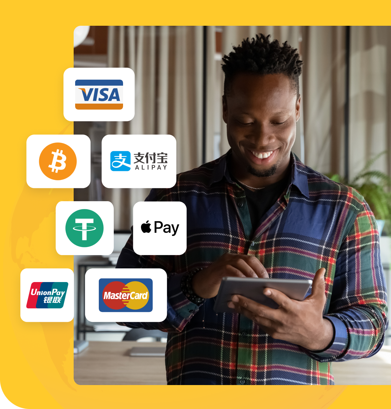 junger Mann lächelnd beim Benutzen seines Tablets mit Logos von Zahlungsmarken wie Visa, PayPal, Alipay, Apple Pay und Union Pay